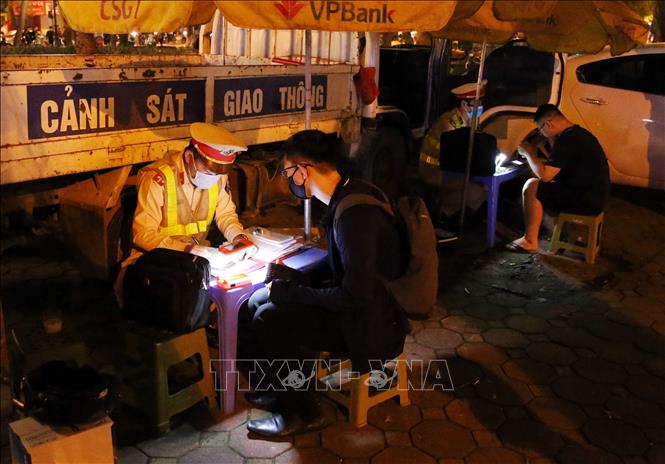 Lực lượng CSGT kiểm tra và lập biên bản xử lý chủ phương tiện vi phạm trật tự ATGT tại phố Phan Đình Phùng, đêm 29 đến rạng sáng 30/4. Ảnh: Phạm Kiên/TTXVN
