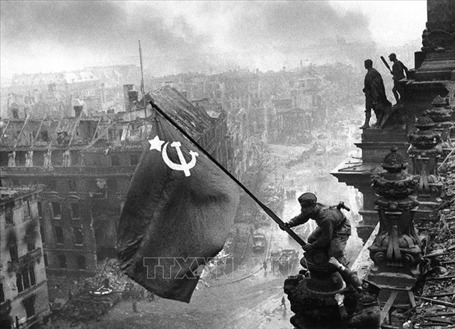 Chiến sĩ Hồng quân thuộc Phương diện quân Byelorussia 1 cắm lá cờ chiến thắng lên nóc Nhà Quốc hội Đức, chiều 30/4/1945. Ảnh: Tư liệu quốc tế/TTXVN phát