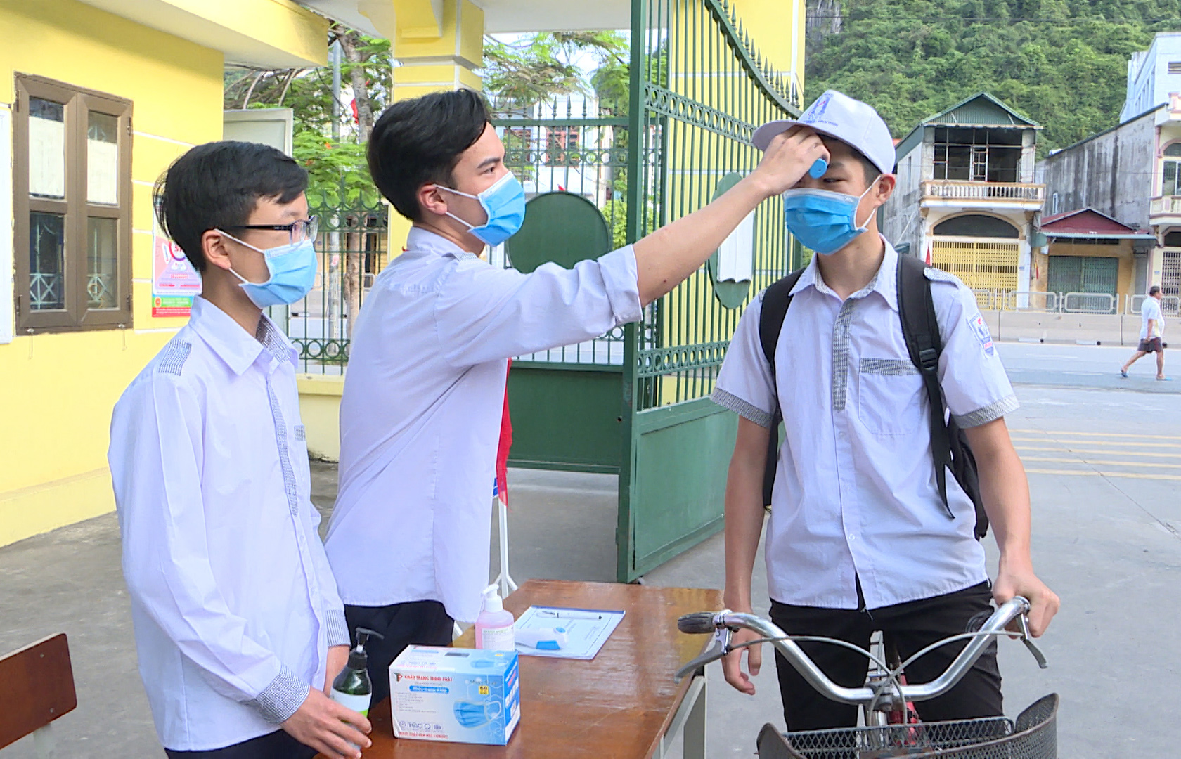 Trước khi vào trường, học sinh THCS Suối Khoáng (TP Cẩm Phả) được đo thân nhiệt và sát khuẩn tay, đảm bảo yêu cầu phòng chống dịch.