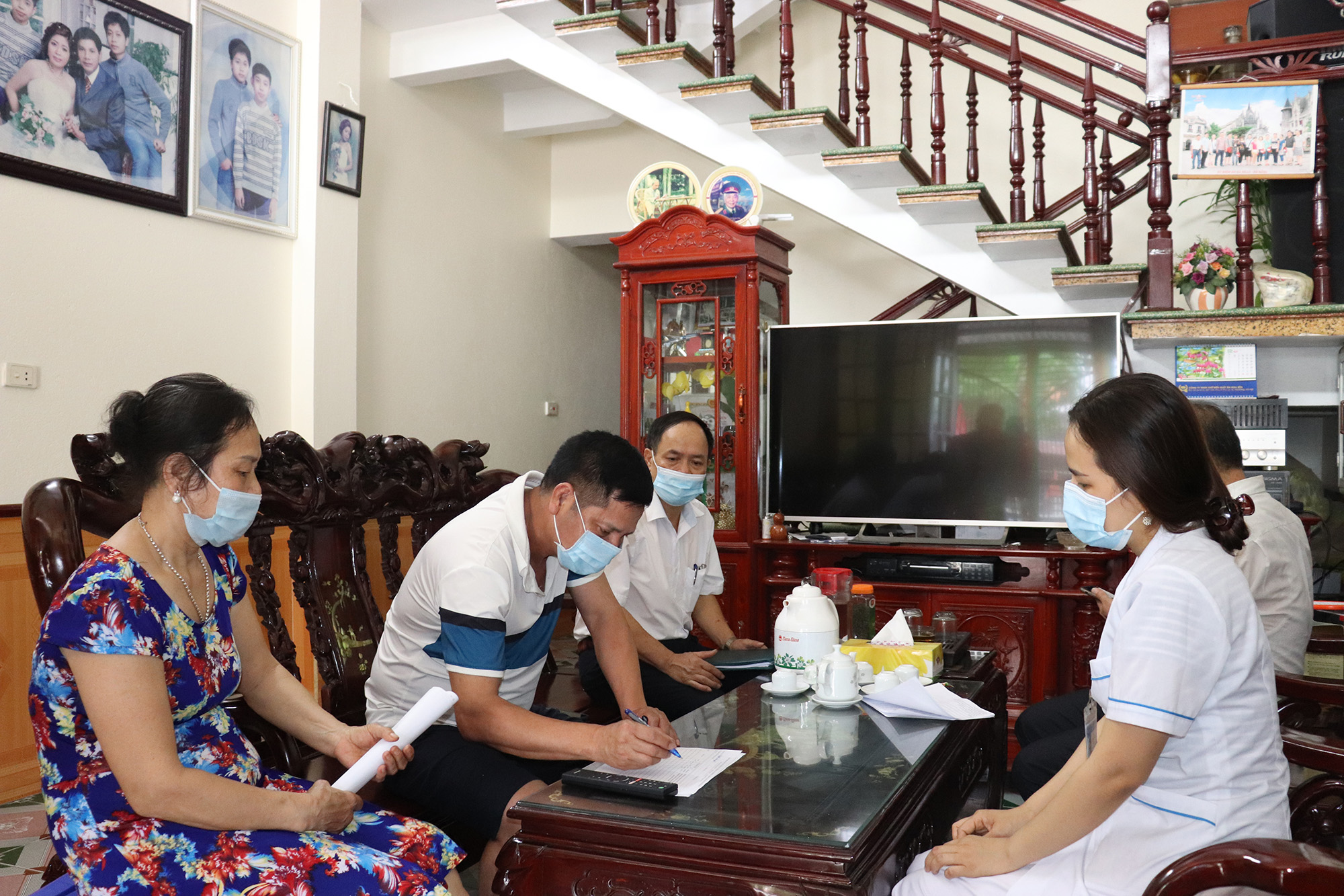 Cán bộ y tế phường Nam Khê, TP Uông Bí, phát tờ khai y tế và hướng dẫn người dân thực hiện khai báo y tế theo đúng quy định.