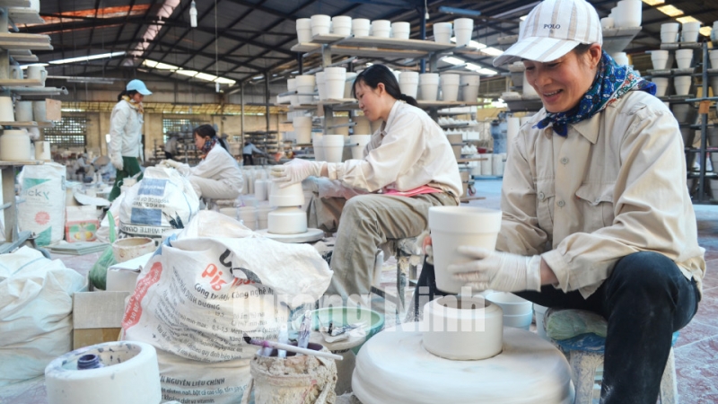 Công nhân của Công ty gốm sứ Quang Vinh thực hiện công đoạn tiện trong quy trình sản xuất sản phẩm (1-2015). Ảnh: Nguyễn Hoa