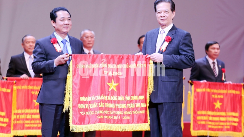 Đồng chí Nguyễn Tấn Dũng, Ủy viên Bộ Chính trị, Thủ tướng Chính phủ, Chủ tịch Hội đồng Thi đua khen thưởng Trung ương tặng cờ thi đua cho TX Đông Triều 1 trong 10 địa phương về đích đầu tiên chương trình nông thôn mới.