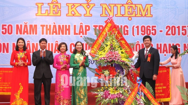 Đồng chí Lê Quang Tùng, Phó Chủ tịch UBND tỉnh trao bức trướng của Tỉnh ủy - HĐND - UBND tỉnh và tặng hoa chúc mừng nhà trường.