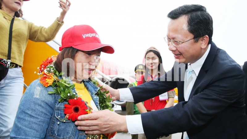 Đồng chí Cao Tường Huy, Phó Chủ tịch UBND tỉnh tặng hoa chúc mừng những vị khách đầu tiên của Vietjet tại sân bay Vân Đồn (20-1-2019). Ảnh: Đỗ Phương
