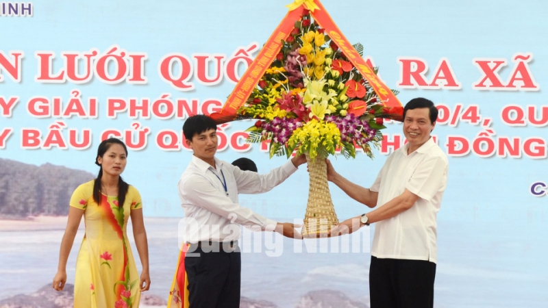 Đồng chí Nguyễn Đức Long, Chủ tịch UBND tỉnh tặng hoa chúc mừng xã đảo Cái Chiên được sử dụng lưới điện quốc gia.