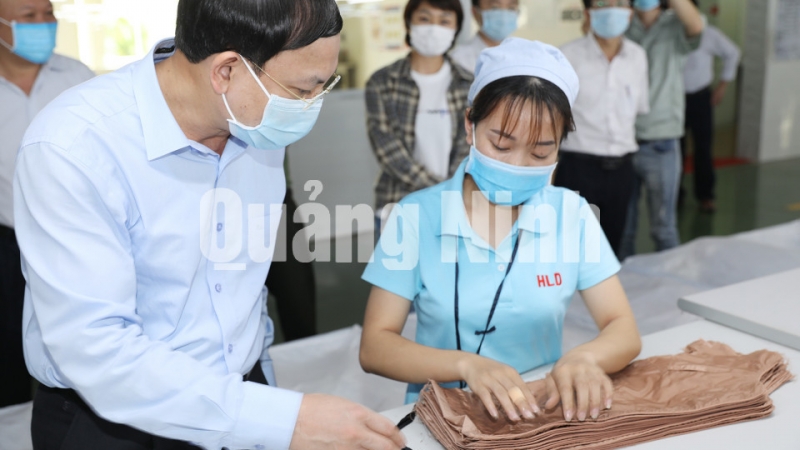 Bí thư Tỉnh ủy Nguyễn Xuân Ký thăm hỏi, động viên công nhân làm việc tại Công ty TNHH may mặc Hoa Lợi Đạt, KCN Cảng biển Hải Hà (5-2020). Ảnh: Đỗ Phương