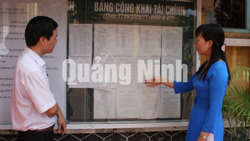Cán bộ Phòng GD&ĐT TP Uông Bí cùng Hiệu trưởng mần non Quang Trung kiểm tra bằng niêm yết tài chính được công khai trường. Ảnh: Nguyễn Dung
