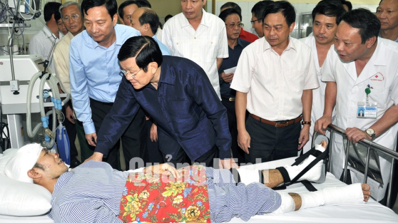 Chủ tịch nước Trương Tấn Sang động viên anh Cao Tiến Vỹ, nạn nhân còn sống sót sau vụ sạt lở đất đá làm sập 3 nhà dân tại phường Cao Thắng (TP Hạ Long)