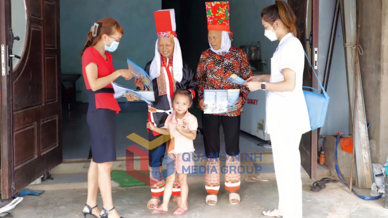 Cán bộ dân số xã Quảng Lâm (huyện Đầm Hà) phát tờ rơi tuyên truyền chính sách DS-KHHGĐ đến người dân (4-2023). Ảnh: Vân Anh
