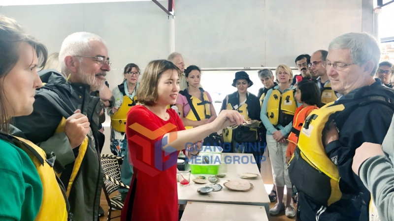 Khách du lịch tìm hiểu về quy trình nuôi trai lấy ngọc ở làng chài Vùng Viêng, TP Hạ Long (4-2019). Ảnh: Bảo Bình