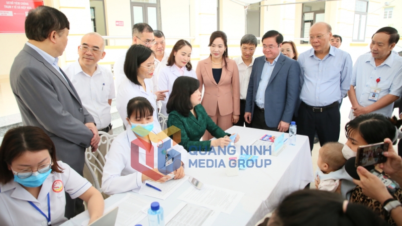 Bộ trưởng Đào Hồng Lan kiểm tra sổ tiêm chủng tại khu vực đón tiếp trẻ đến tiêm vắc-xin sởi tại Trạm Y tế xã Hiệp Hoà (3-2025). Ảnh: Minh Hà