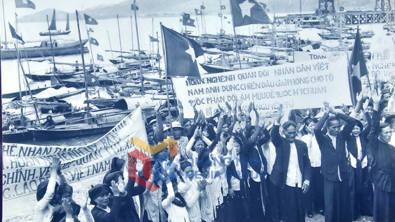 Bà con ngư dân ở Hòn Gai đón bộ đội vào tiếp quản, giương cao biểu ngữ phản đối âm mưu đế quốc Mỹ chuẩn bị chiến tranh nguyên tử. Ảnh: Tư liệu