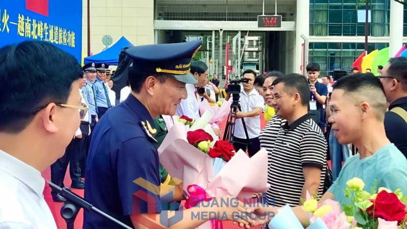 Đại diện Hải quan cửa khẩu Bắc Phong Sinh tặng hoa chào mừng những hành khách Trung Quốc đầu tiên xuất nhập cảnh vào Việt Nam sau lễ vận hành (5-2025). Ảnh: Hoàng Nga