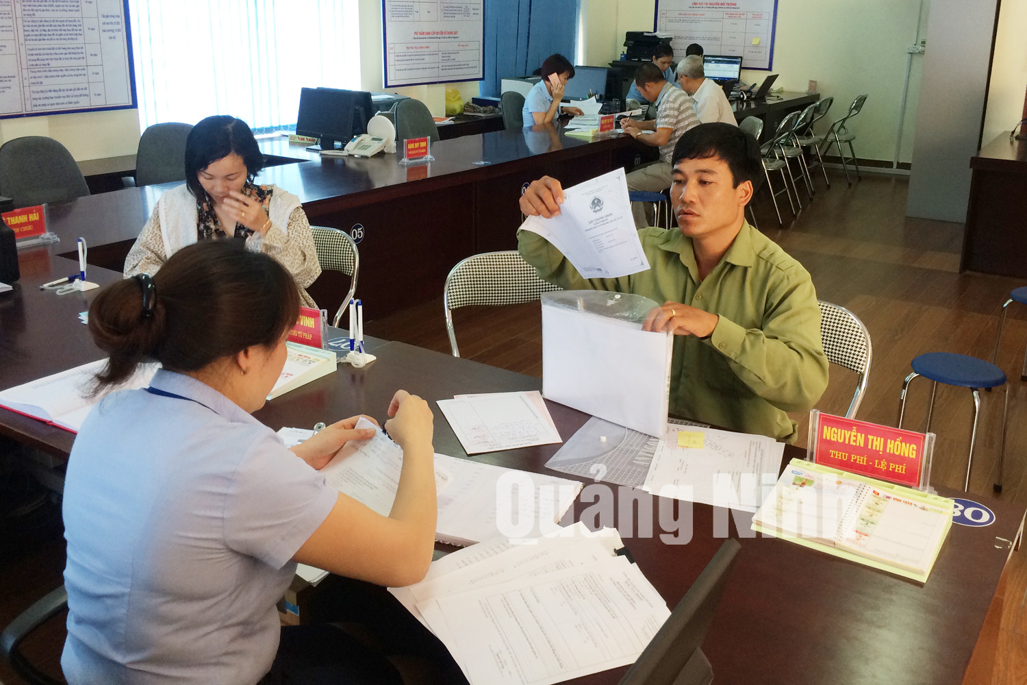 Cán bộ Trung tâm Hành chính công TP Uông Bí hướng dẫn người dân làm thủ tục hành chính. Ảnh Cao Quỳnh