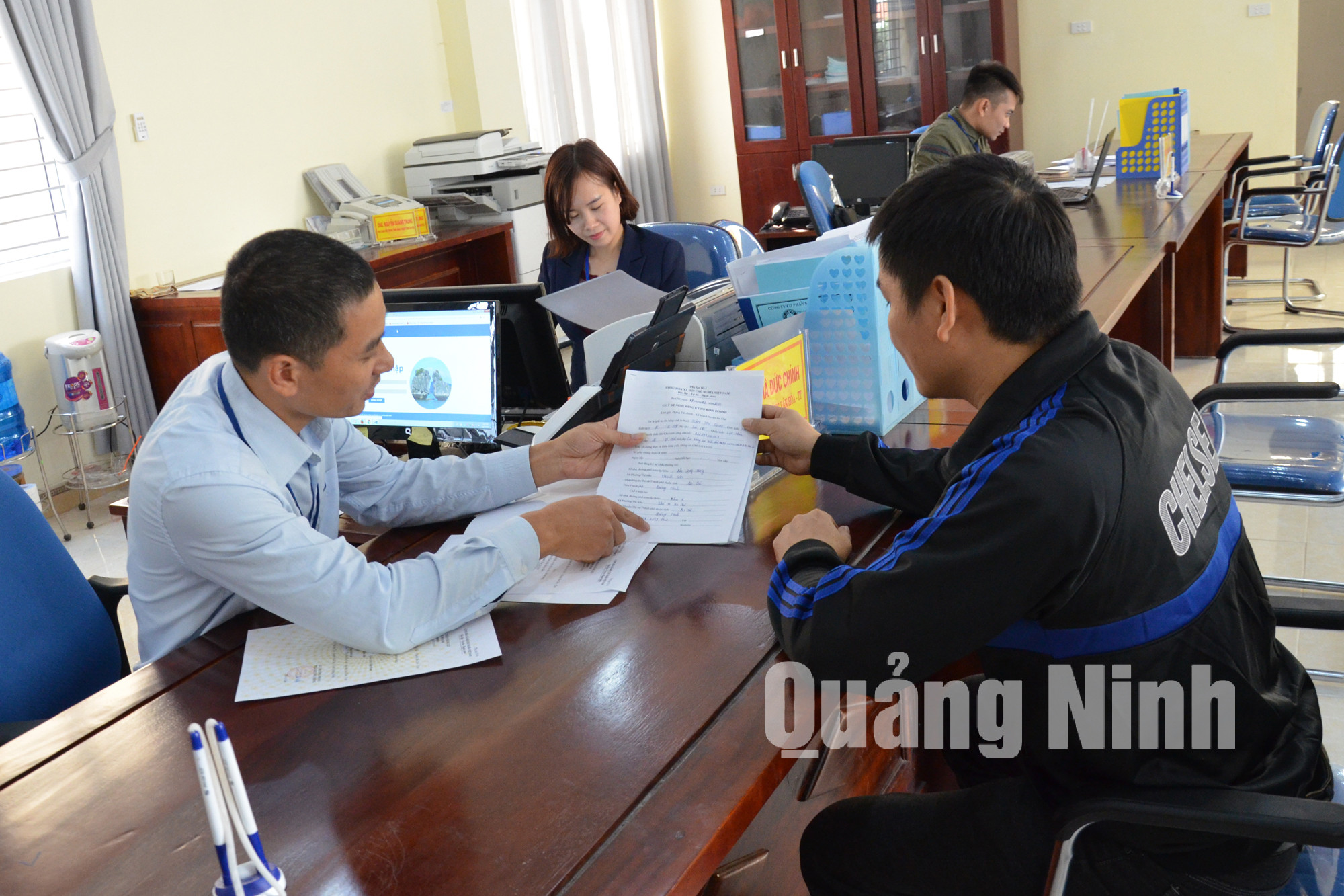 Cán bộ TT HCC huyện Ba Chẽ hướng dẫn người dân đến giải quyết thủ tục hành chính. Ảnh Nguyễn Thanh
