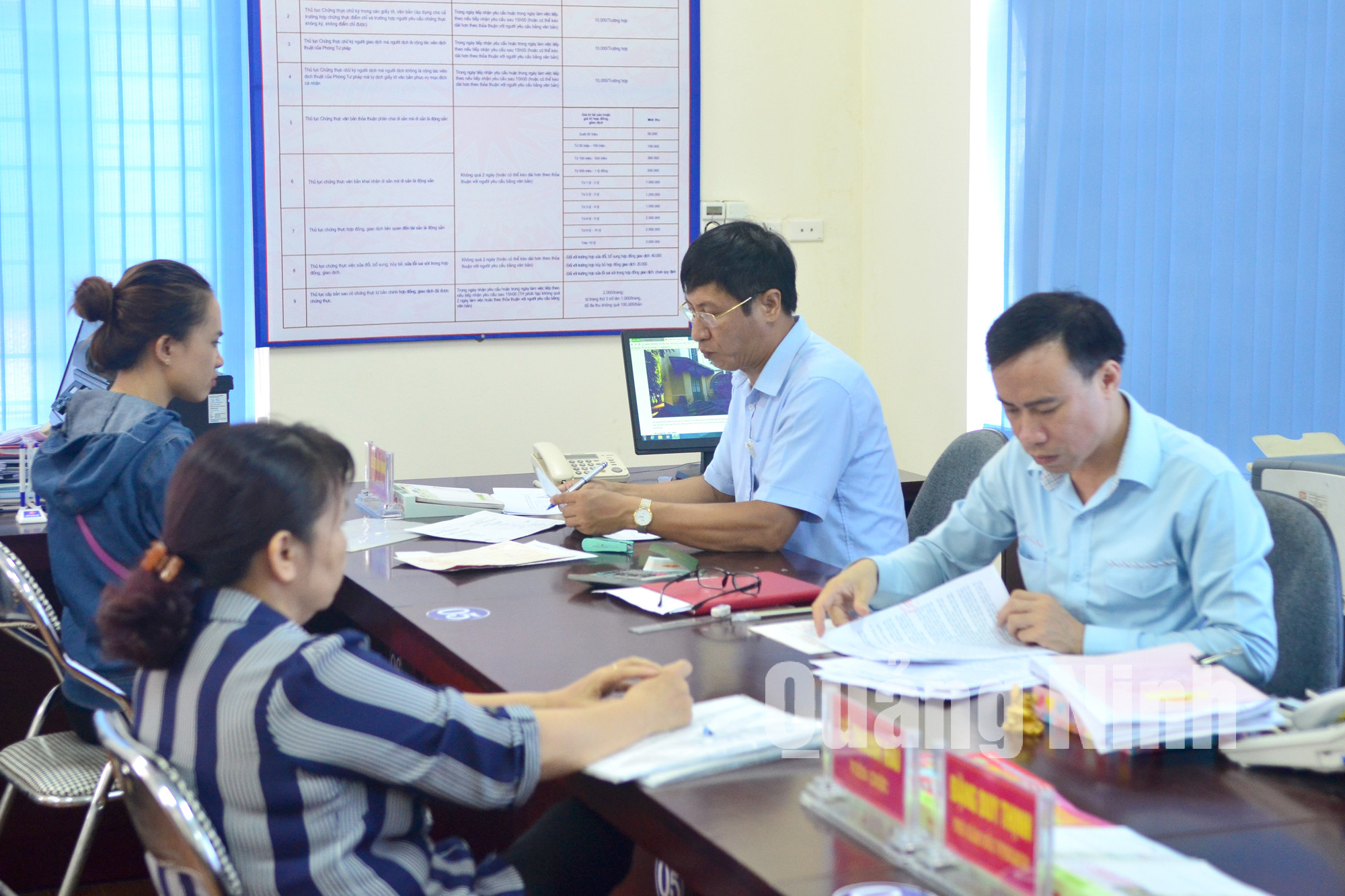 Cán bộ Trung tâm Hành chính công TP Uông Bí nhận hồ sơ của công dân đến giao dịch. Ảnh: Lan Anh