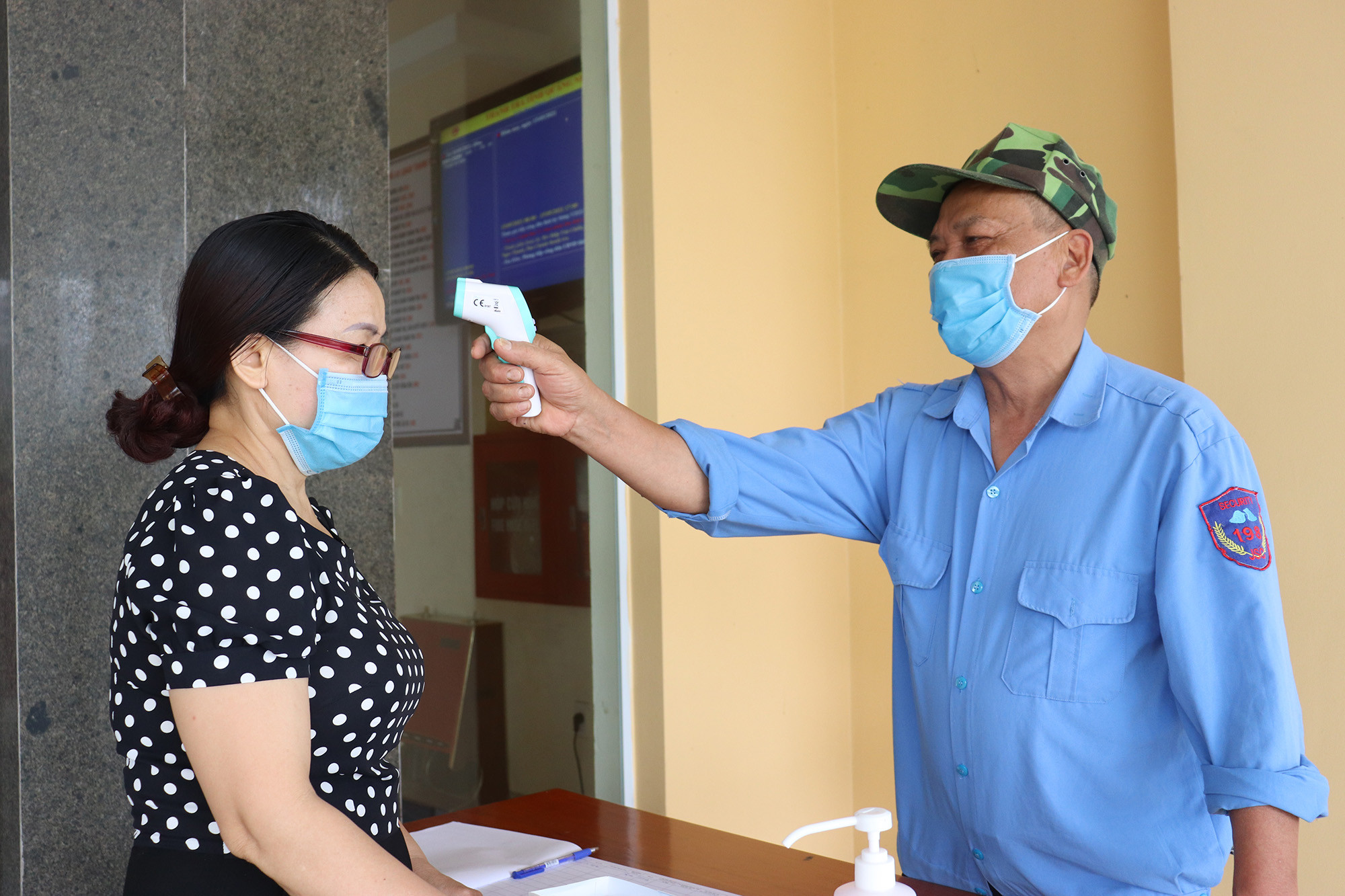 Cán bộ đi làm vào ngày thứ 7 chấp hành nghiêm việc đo thân nhiệt phòng dịch.