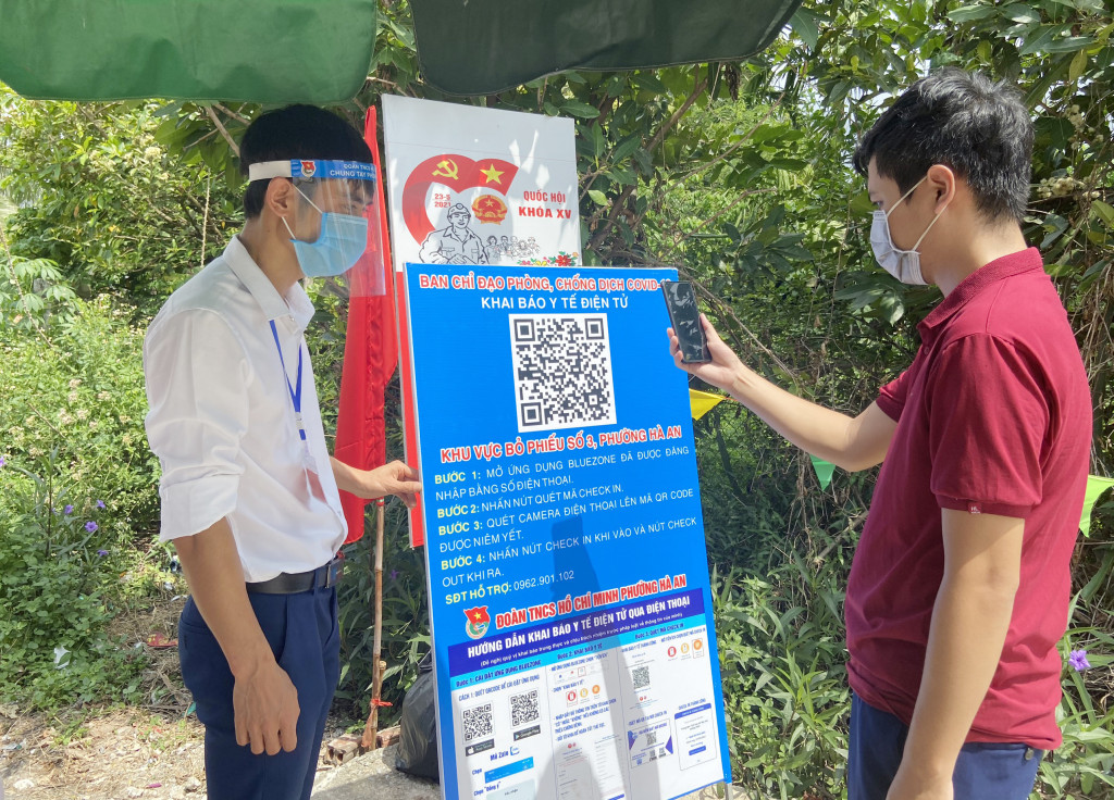 Cử tri phường Hà An thực hiện quét mã Qr khai báo y tế trước khi vào bỏ phiếu tại khu vực bỏ phiếu số 3