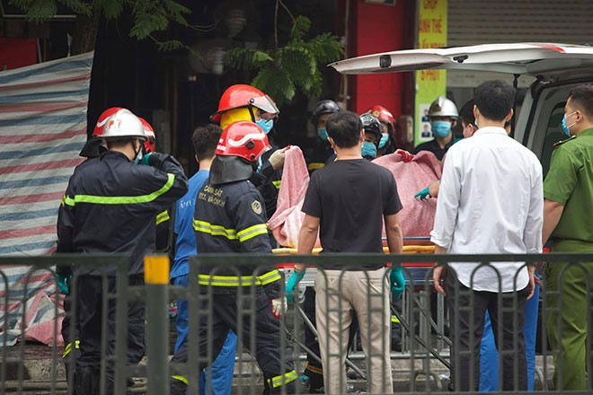 Hiện trường vụ cháy xảy ra đêm 4/4 tại phố Tôn Đức Thắng, nạn nhân đang được đưa ra ngoài. Ảnh: LĐO