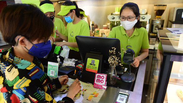 Khách hàng thanh toán tiền bằng ứng dụng MoMo tại quán cà phê trên đường Nguyễn Đình Chiểu, quận 1, TP.HCM - Ảnh: QUANG ĐỊNH