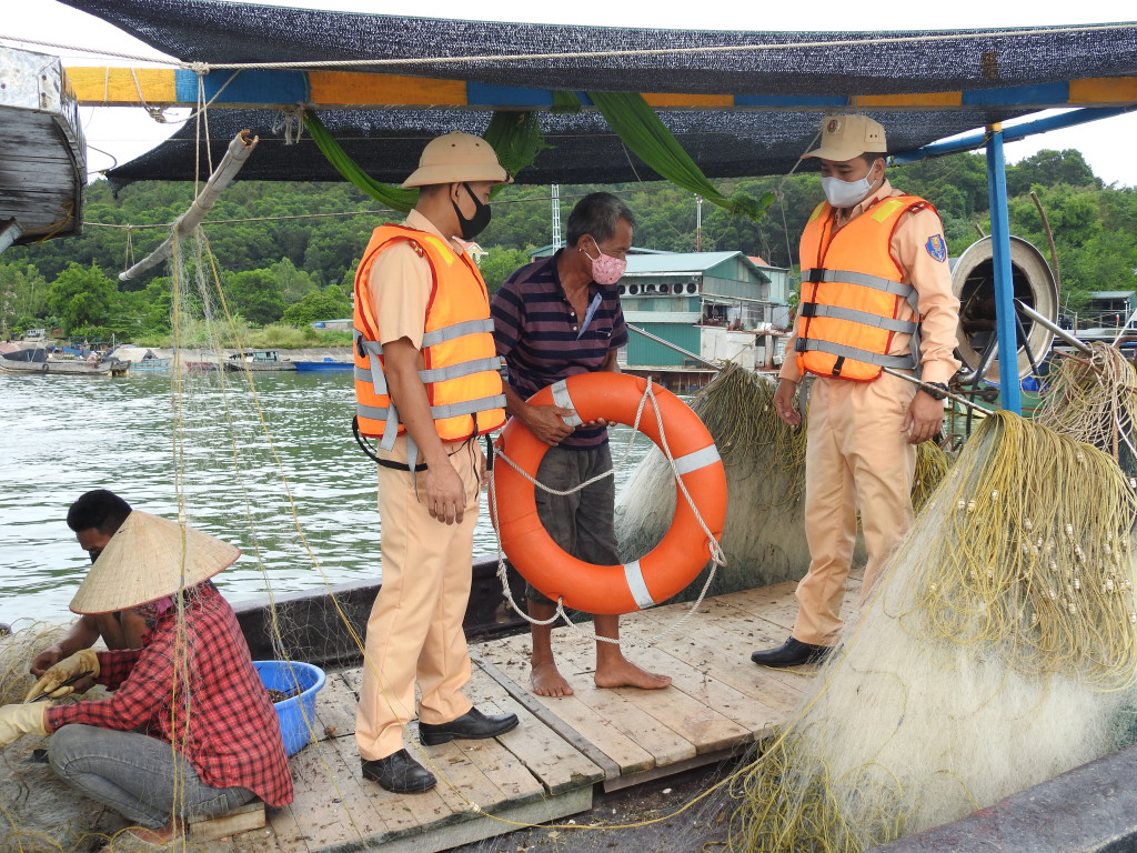Cảnh sát giao thông Công an TP Móng Cái kiểm tra và tuyên truyền cho bà con ngư dân tại khu vực bến Mũi Ngọc, phường Bình Ngọc về công tác đảm bảo trật tự ATGT đường thủy.