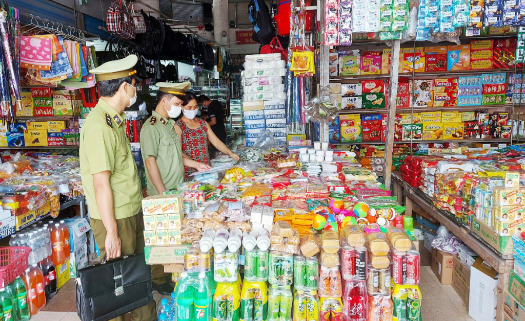Lực lượng QLTT huyện Tiên Yên tuyên truyền tới các hộ kinh doanh chấp hành nghiêm quy định về kinh doanh thương mại gắn với phòng chống dịch Covid-19.