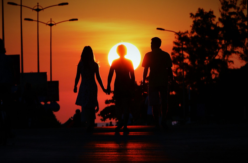 Đôi vợ chồng và con gái dắt nhau đi tắm biển buổi sớm, trên đường Nguyễn Huệ, TP.Tuy Hòa. Lúc này khoảng 6 giờ sáng, nắng đầu ngày in những bóng người trên nền trời vàng rực