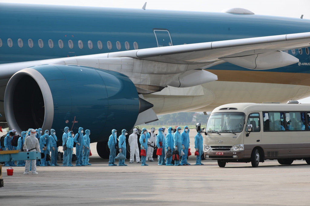 Các cơ quan chức năng phối hợp với Hãng hàng không quốc gia Việt Nam thực hiện chuyến bay đặc biệt đón công dân Việt Nam từ Guinea Xích đạo về nước. Toàn bộ công dân và phi hành đoàn được làm xét nghiệm và đưa tới cơ sở cách ly y tế tập trung theo đúng quy định về phòng, chống COVID-19_Ảnh: TTXVN