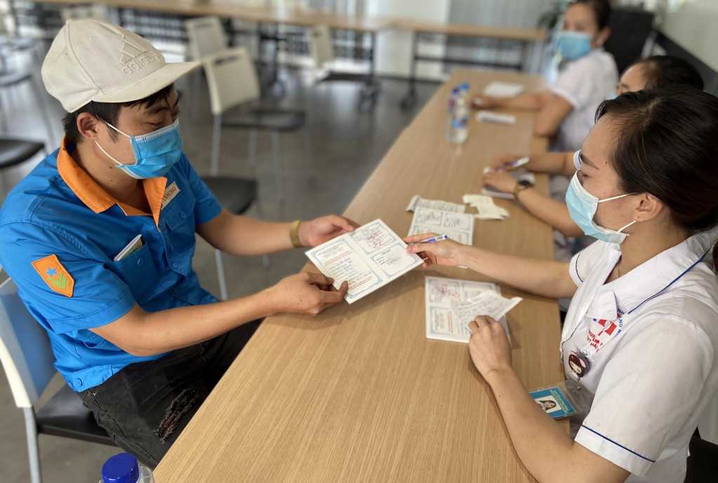 Sau khi tiêm, công nhân, người lao động Công ty TNHH Khoa học Kỹ thuật Texhong Ngân Hà được cấp giấy xác nhận tiêm vắc-xin Covid-19. 