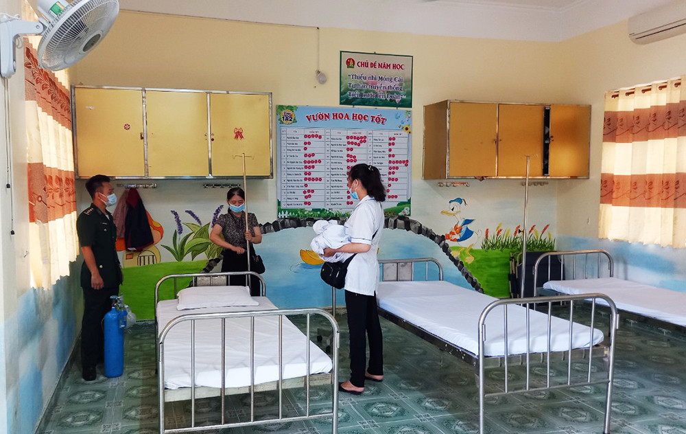 Cán bộ Đồn Biên phòng CKQT Móng Cái phối hợp chuẩn bị cơ sở vật chất tiêm vắc xin phòng chống Covid - 19 cho người dân trên địa bàn phường Trần Phú (TP Móng Cái)