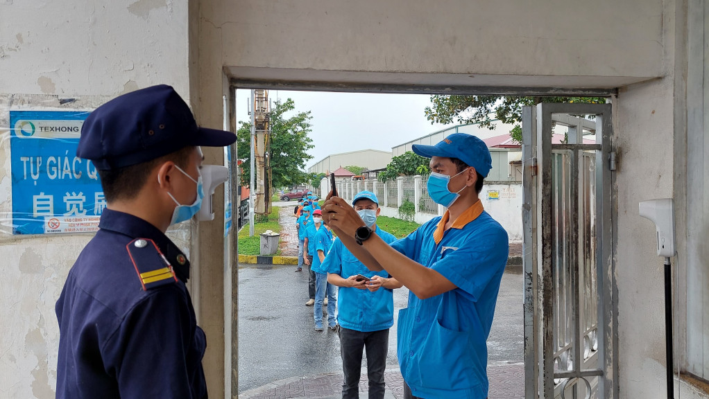 Công nhân Công ty TNHH Khoa học-Kỹ thuật Texhong Ngân Long (KCN Hải Yên, Móng Cái) thực hiện khai báo y tế, phòng chống dịch Covid-19 trước khi vào ca sản xuất.