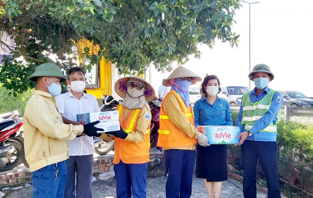 Chủ tịch Công đoàn Công ty CP Cầu Phà Quảng Ninh-Phạm Thị Hương (thứ 2 từ trái sang) tặng nước uống cho công nhân vệ sinh cầu Bãi Cháy trong thời tiết nắng nóng.