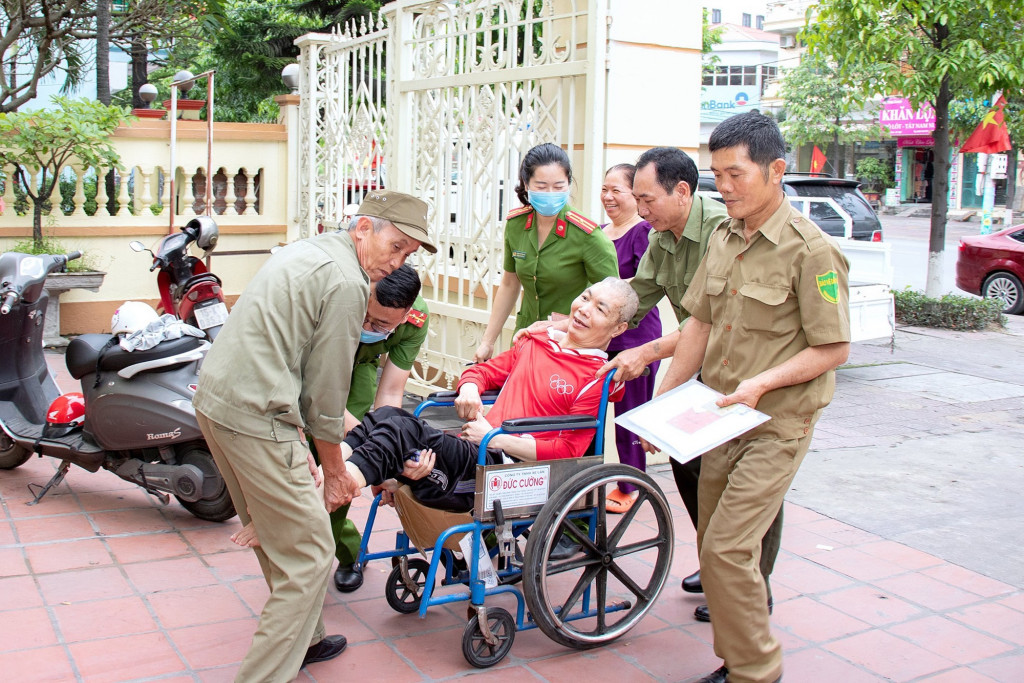Công an phường Cẩm Thạch (TP Cẩm Phả) hỗ trợ đưa người khuyết tật đến trụ sở Công an phường để làm căn cước công dân.