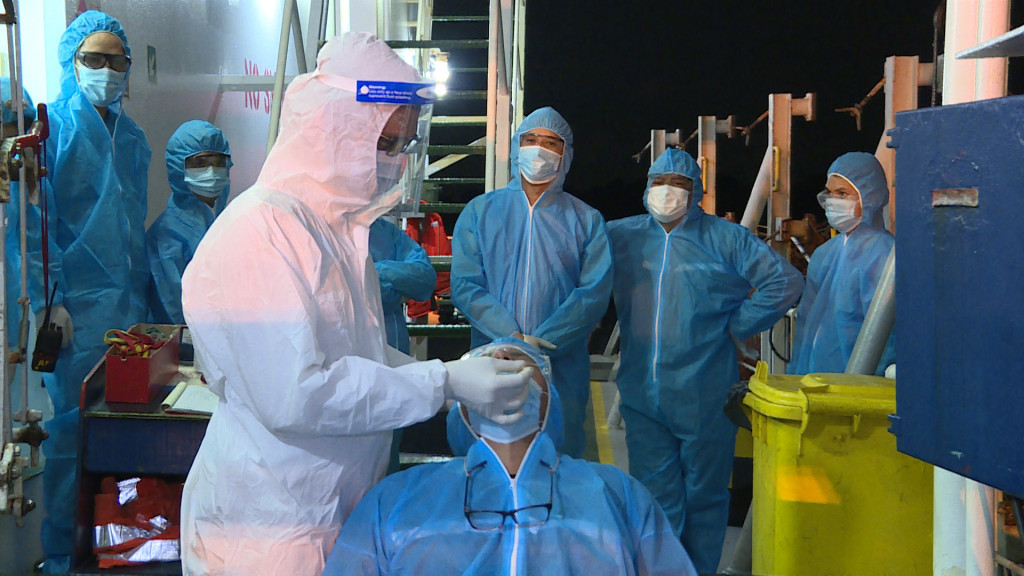 Kiểm dịch viên Trung tâm Y tế quốc tế Quảng Ninh lấy mẫu xét nghiệm Covid-19 cho thuyền viên trên tàu. Ảnh: Nguyễn Trang