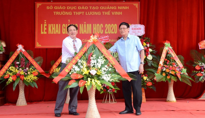 Ông Hoàng Hồng tặng hoa của Hội Khuyến học Quảng Ninh chúc mừng Trường THPT Lương Thế Vinh, Cẩm Phả nhân dịp khai giảng năm học mới.