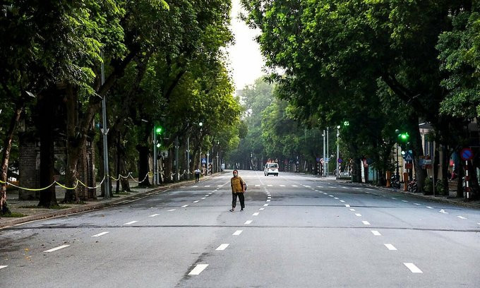A woman walks on a deserted street around the Sword Lake in Hanoi downtown amid the city's Covid social distancing order, July 24, 2021.
