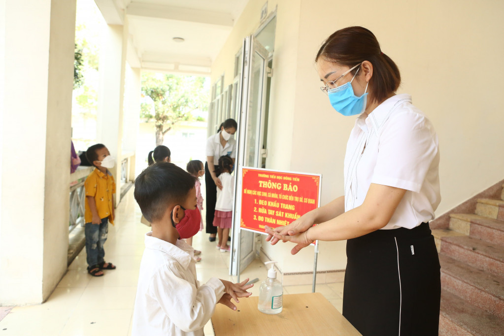 Các em học sinh được hướng dẫn sát khuẩn tay trước khi vào lớp học.