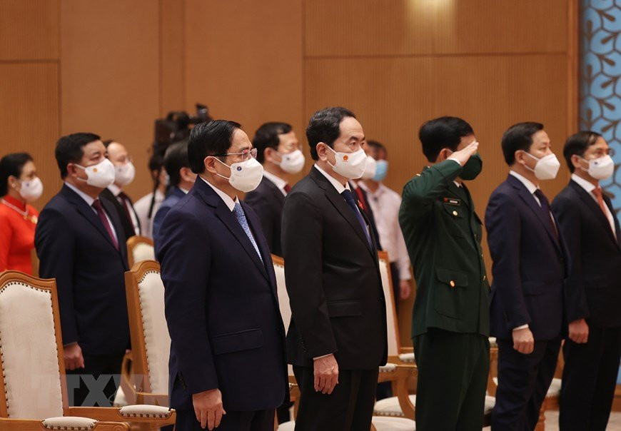 Prime Minister Pham Minh Chinh and delegates salute the flag.