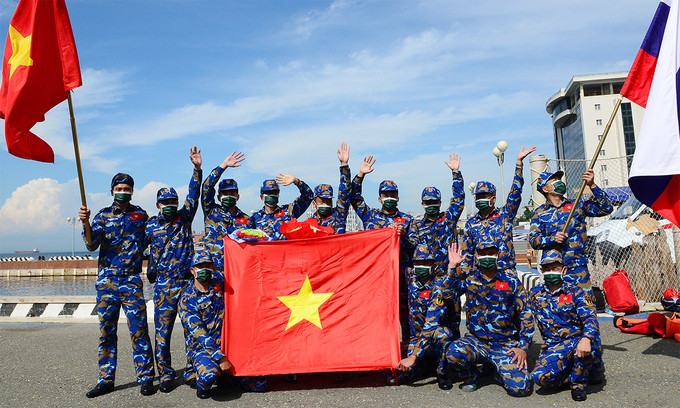 Members of the Vietnamese navy team pose jubilantly with the national flag after completing the Use of Rescue Equipment competition at the 2021 Army Games in Vladivostok, Russia, August 27, 2021.