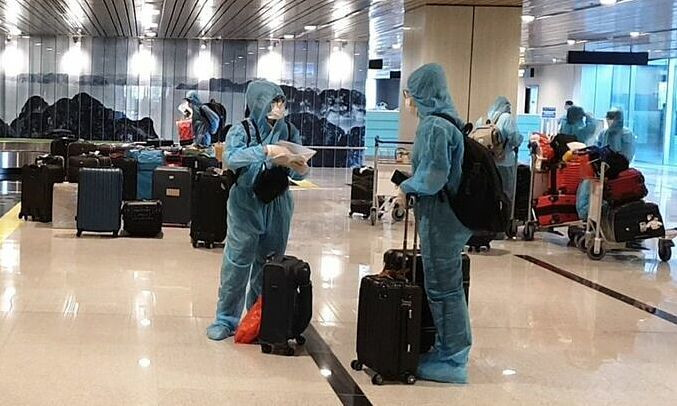 Passengers wait to get their luggage after arriving at Van Don Airport in Quang Ninh Province on a flight from Japan, September 4, 2021