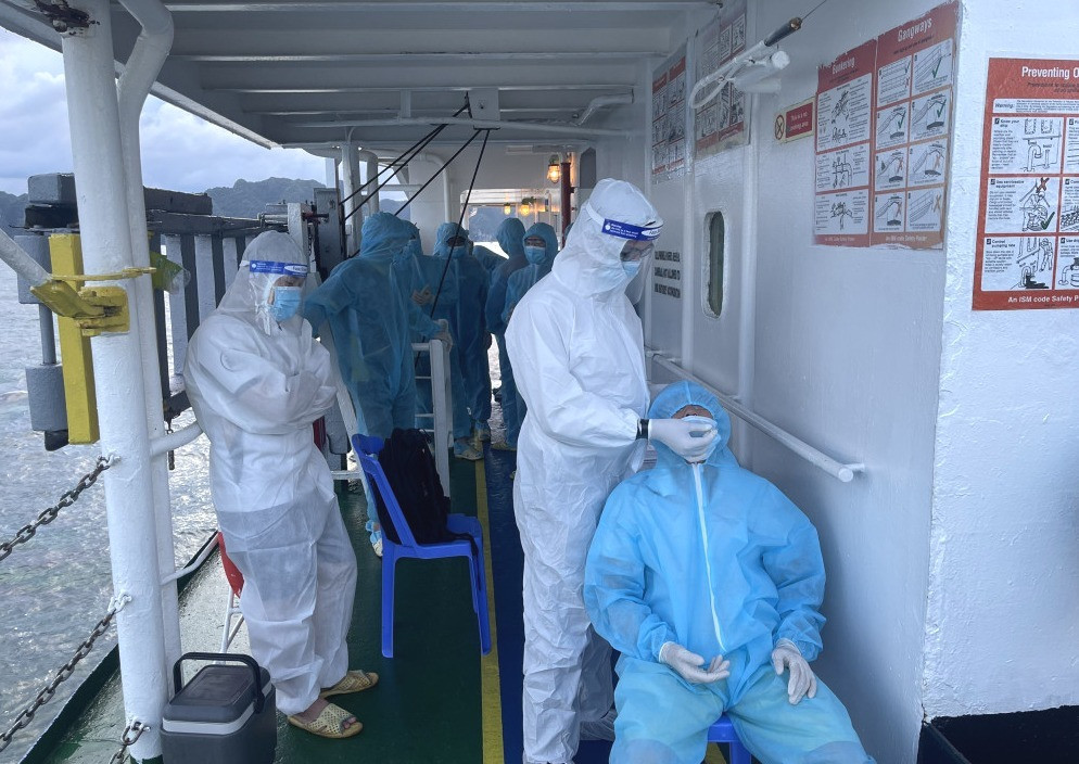 Nhân viên Trung tâm Kiểm dịch y tế Quốc tế Quảng Ninh lấy mẫu xét nghiệm cho thuyền viên trên tàu nhập cảnh vào Quảng Ninh.