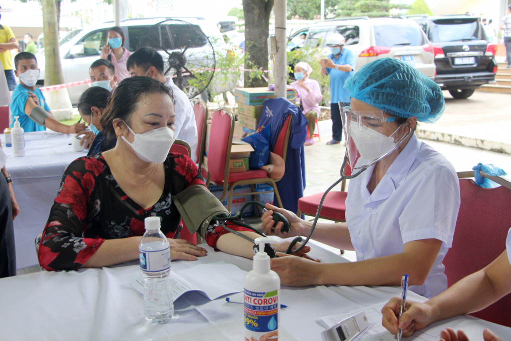 Cán bộ y tế khám sàng lọc cho người dân TP Hạ Long trước khi tiêm vắc xin phòng Covid-19.
