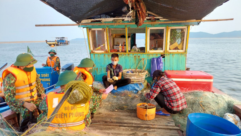 Cán bộ, chiến sỹ Đồn Biên phòng Trà Cổ tuyên truyền cho bà con ngư dân về công tác phòng, chống dịch Covid-19 và phòng chống XNC trái phép trên biển.