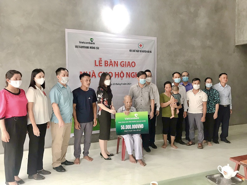 Đại diện Ngân hàng Vietcombank Chi nhánh Móng Cái trao tặng tiền hỗ trợ xây nhà cho gia đình ông Phamj Văn Thâu.