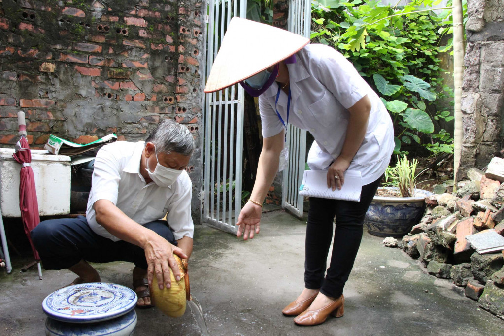 Nhân viên y tế TX Quảng Yên hướng dẫn người dân trên địa bàn thị xã lật úp vật dụng chứa nước, không để muỗi gây bệnh SXH sinh trưởng. Ảnh: Ánh Tuyết (TTTT-VH Quảng Yên).