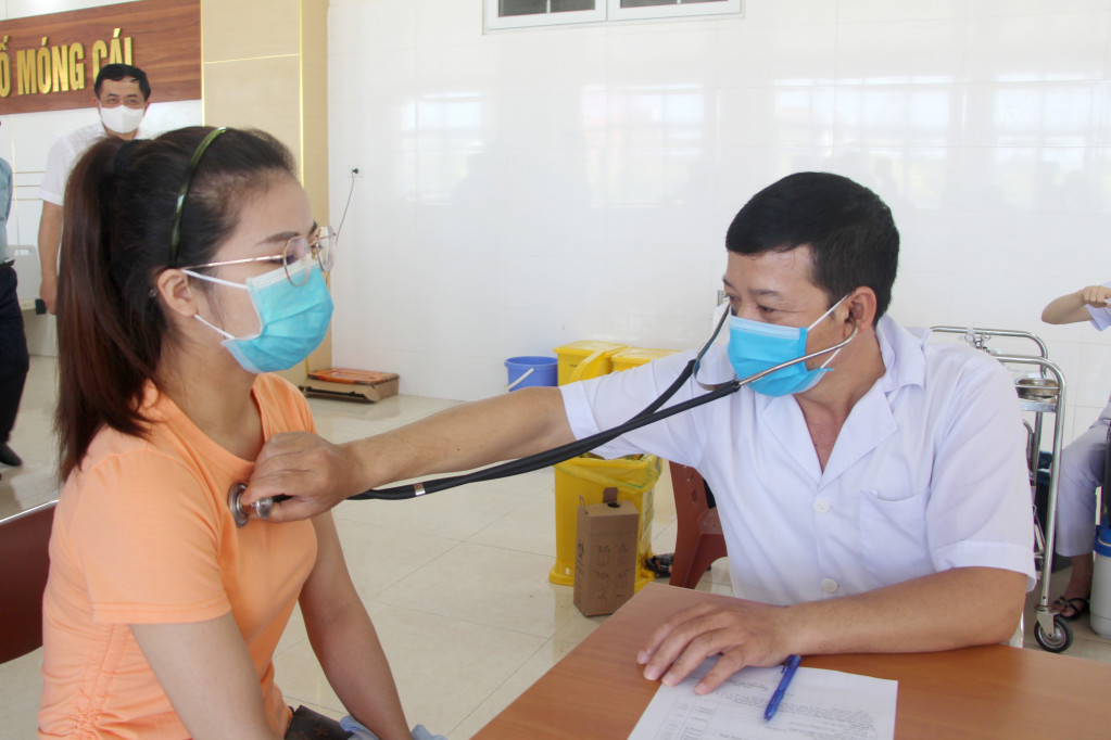 Người dân TP Móng Cái được khám sàng lọc trước khi tiêm vắc xin phòng Covid-19.