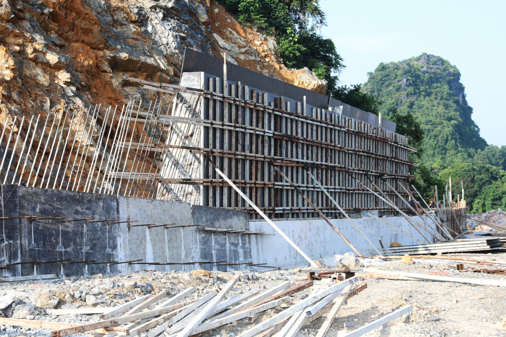Contractors are constructing embankments on mountain slopes to prevent landslides, falling rocks, and ensure safety for vehicles when traveling on the route.
