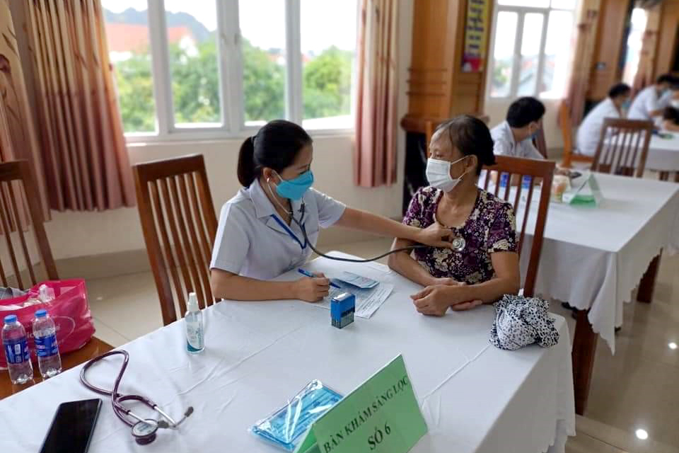 Cán bộ y tế khám sàng lọc cho người dân Cẩm Phả trước khi tiêm vắc xin.