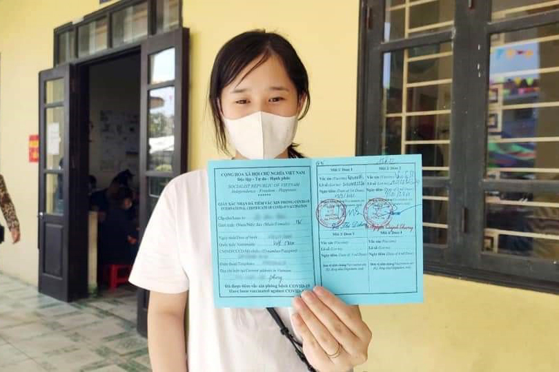 Người dân TP Uông Bí nhận giấy xác nhận tiêm đủ 2 mũi vắc xin.