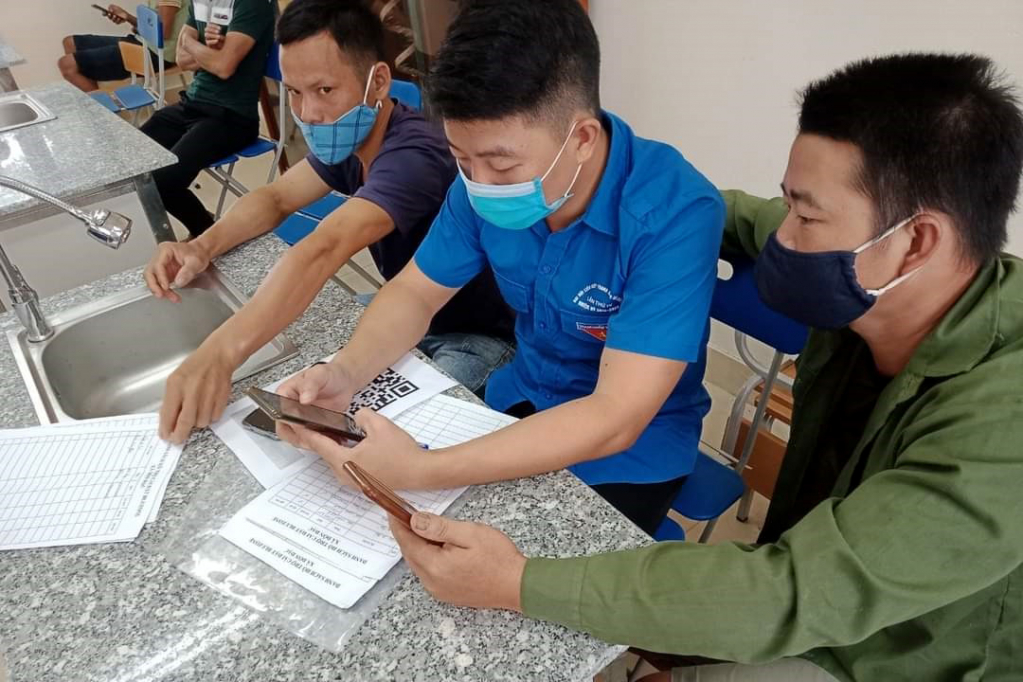 Đoàn viên thanh niên huyện Ba Chẽ hướng dẫn người dân khai báo y tế trước khi vào tiêm.